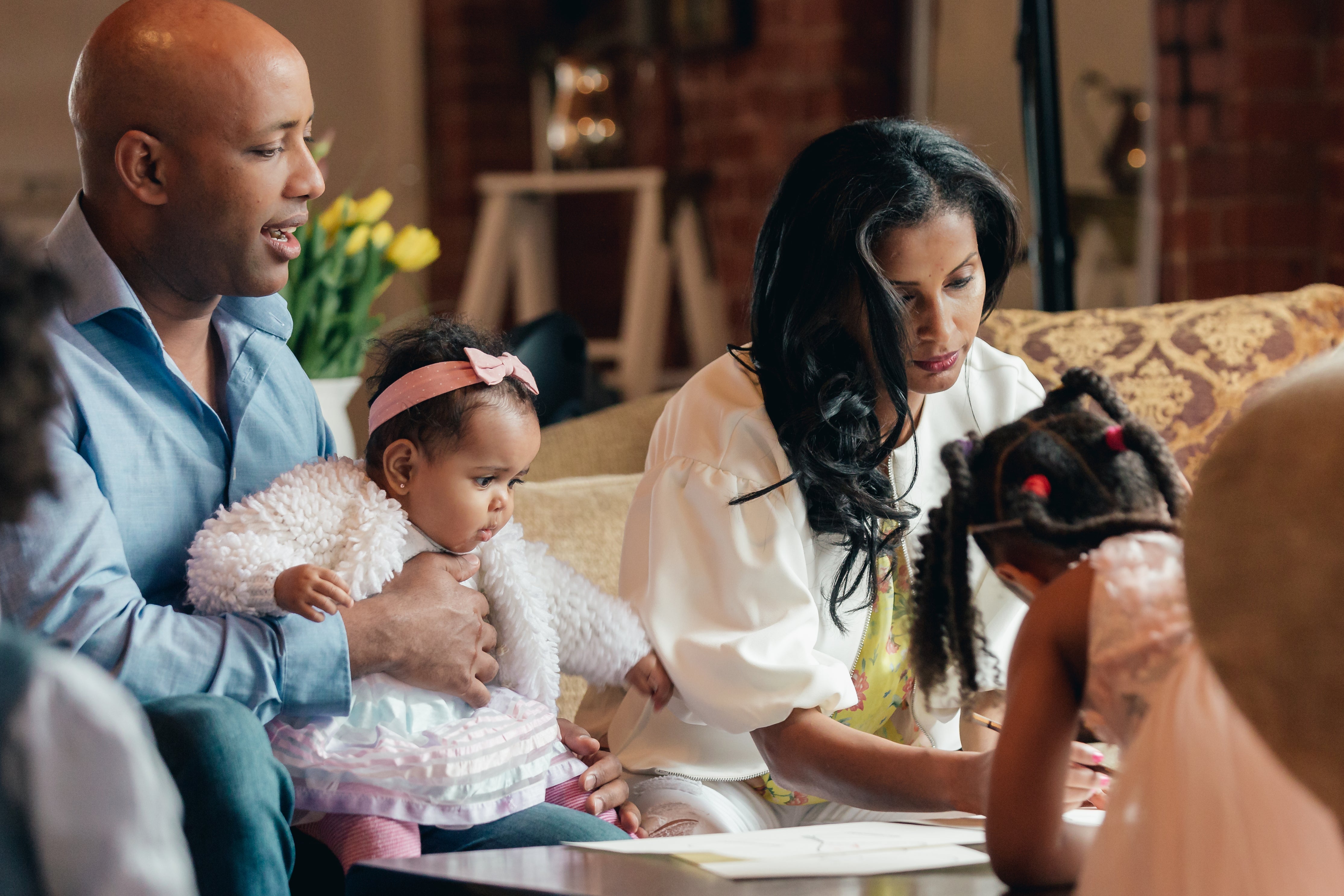 Parents hang out with their daughters in the family room.