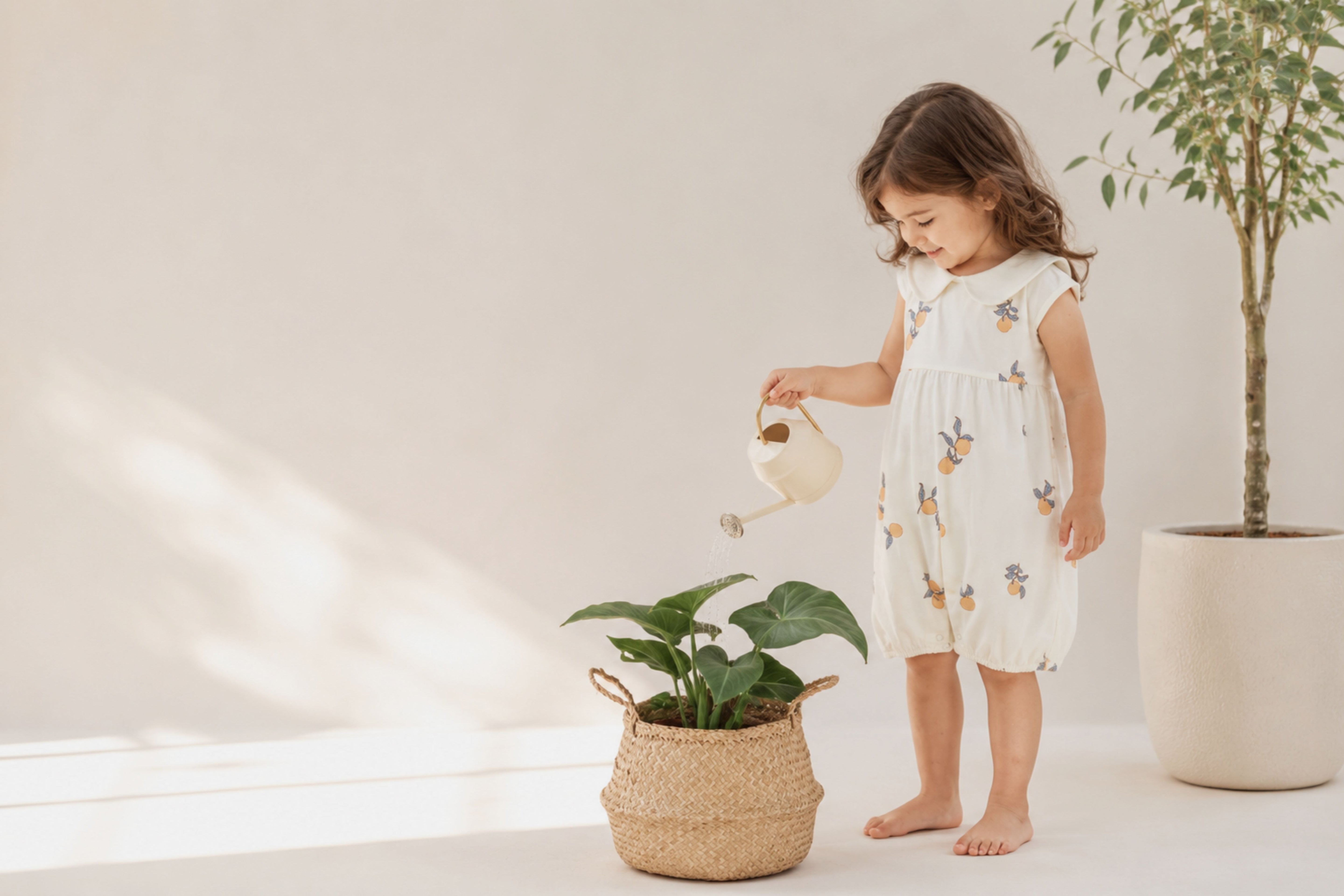 baby girl in norsu organic dress watering a plant