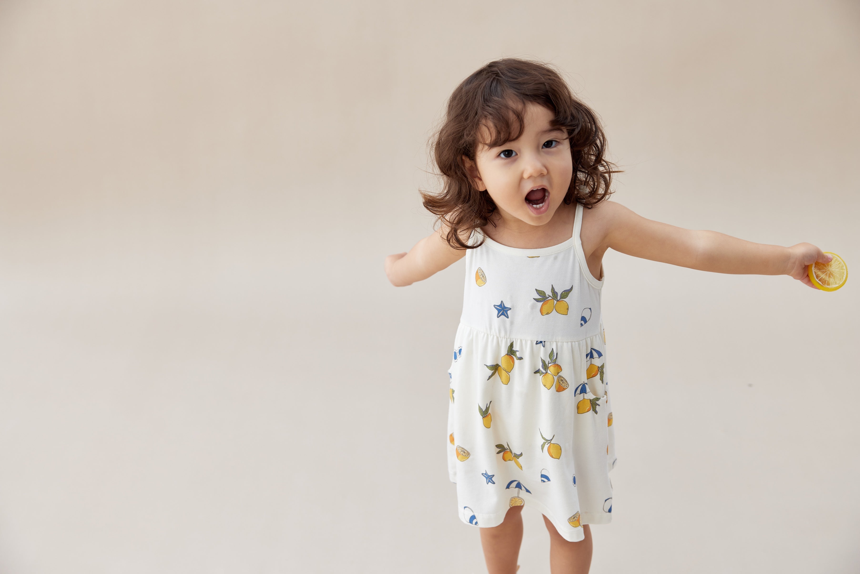 Baby girl wearing norsu organic lemon dress