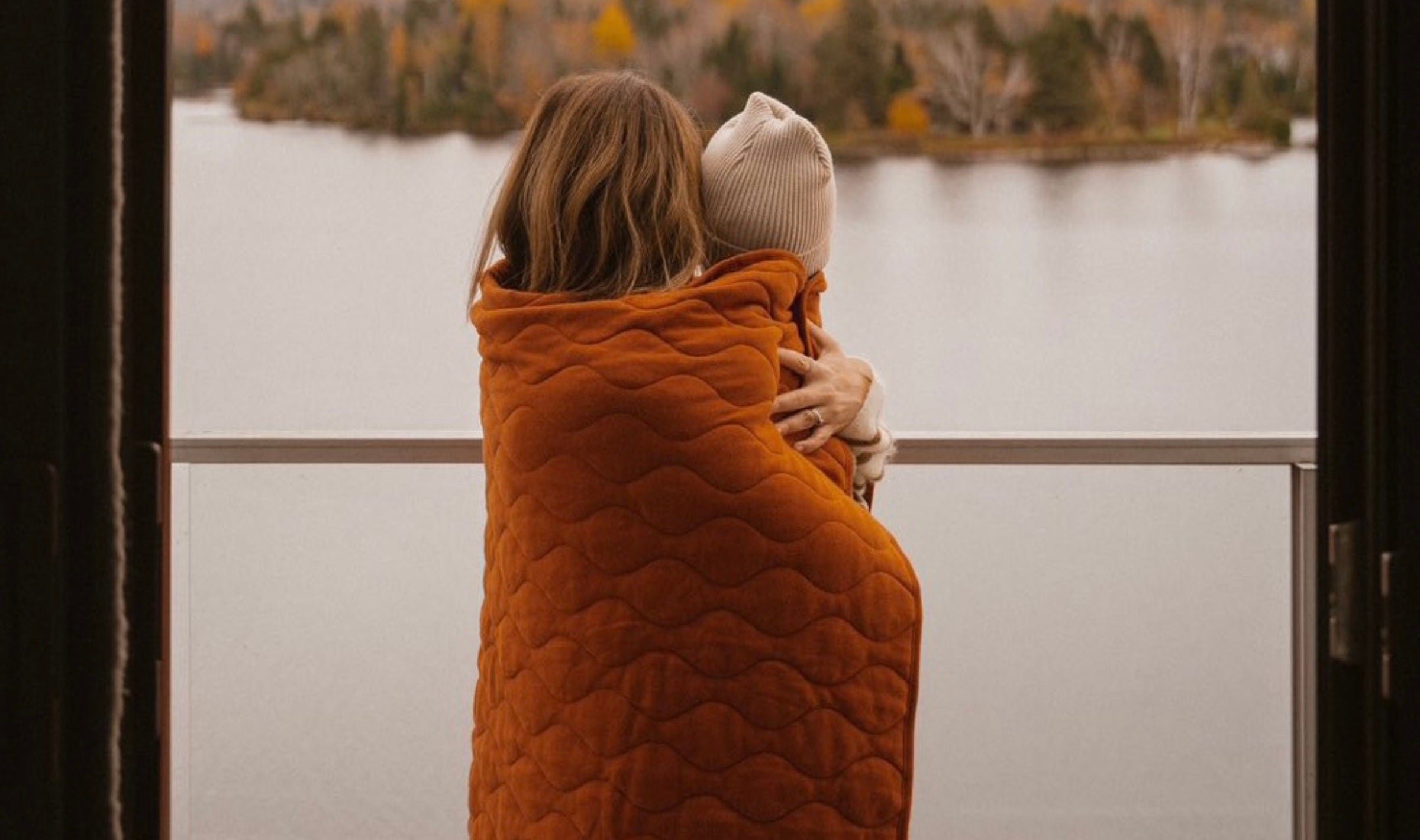 mommy hold a baby and wearing norsu organic rust quilt blanket 