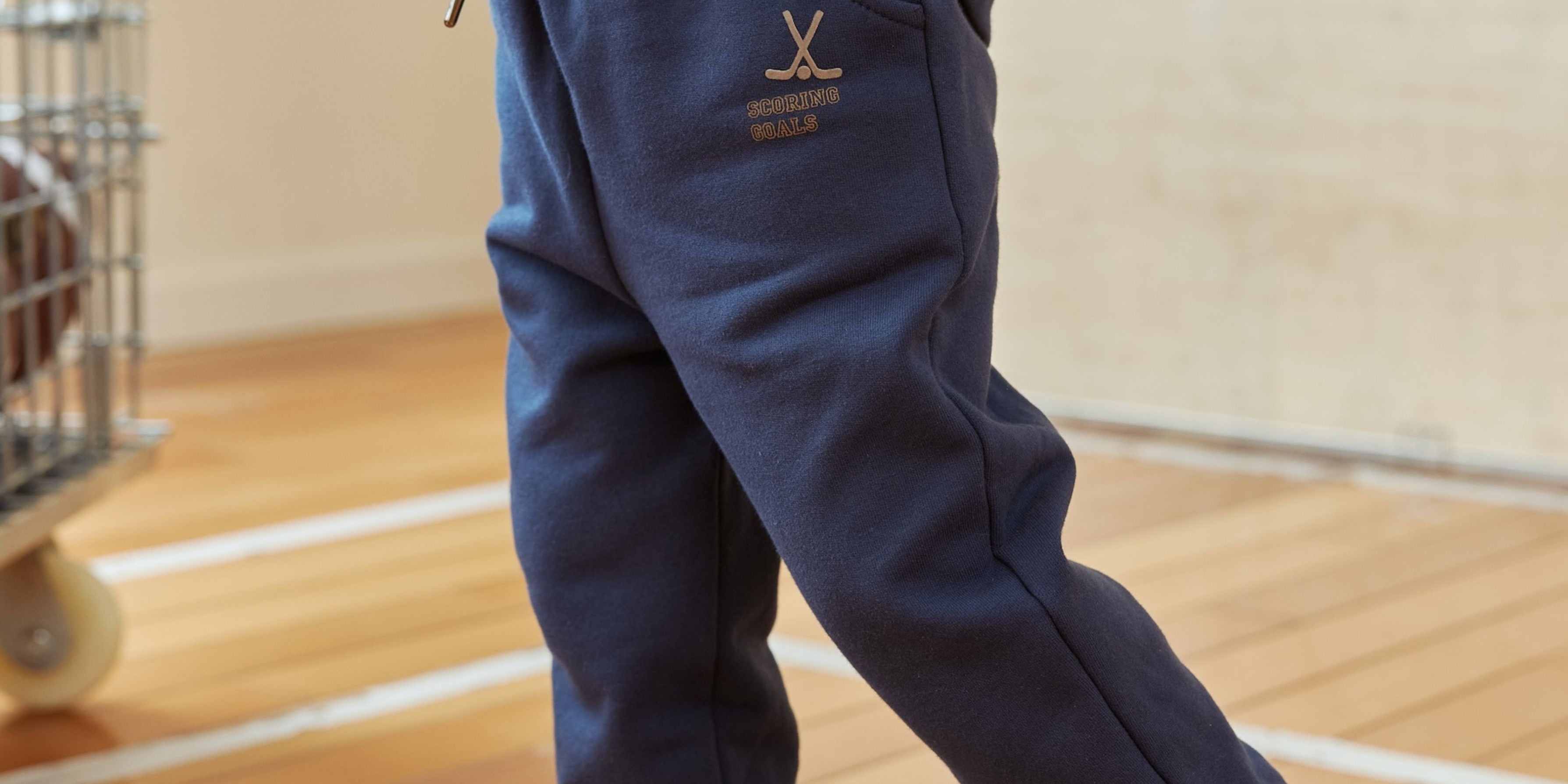 Navy blue tracksuit with a logo on a wooden floor