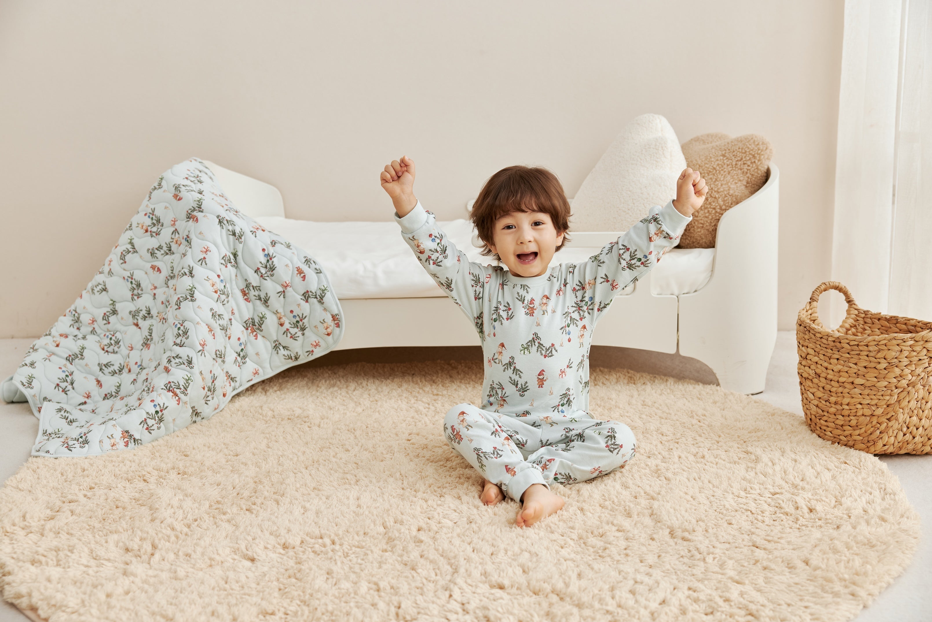 Baby girl and baby boy are wearing norsu organic holiday season pajamas and onesie, playing on the bed 