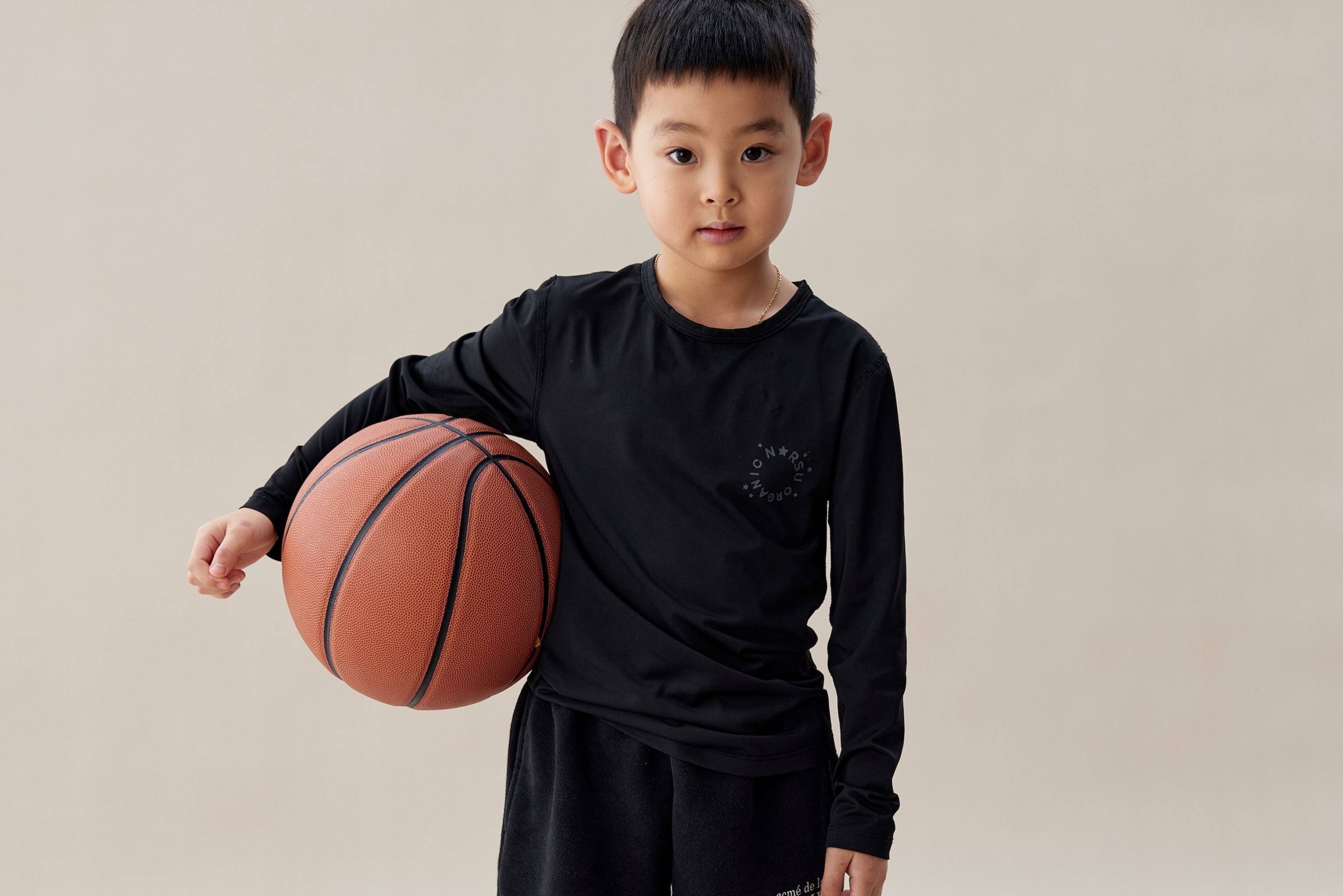 boy holding a basketball standing in a warm background