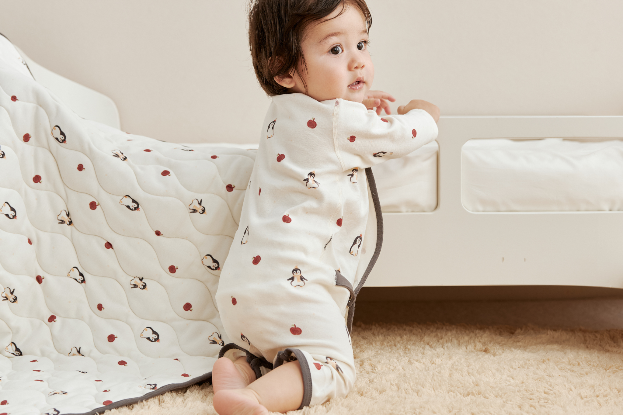 baby girl beside the bed and playing
