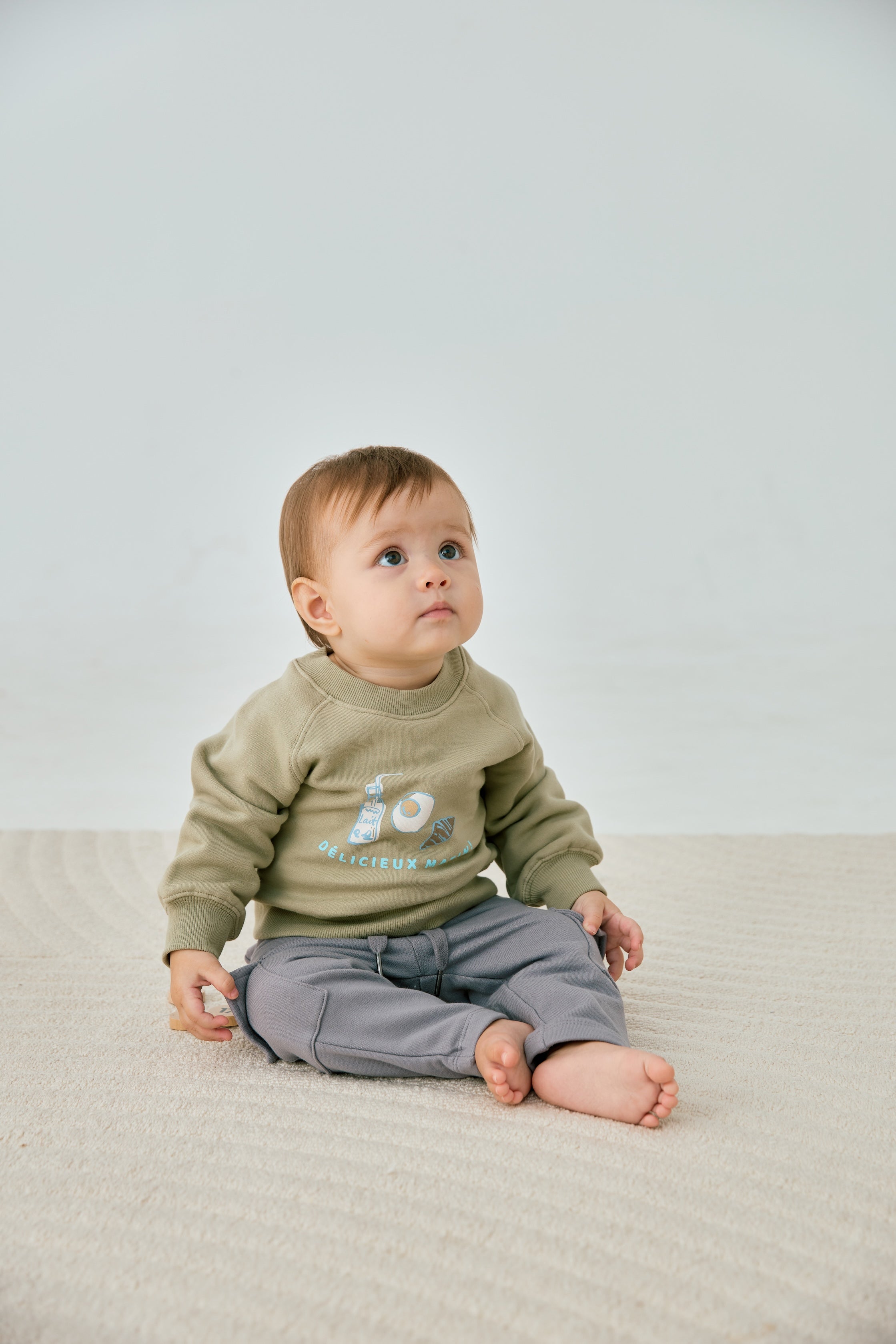 baby sitting and wearing Toddler Organic Fleece Sweatshirt-Milky