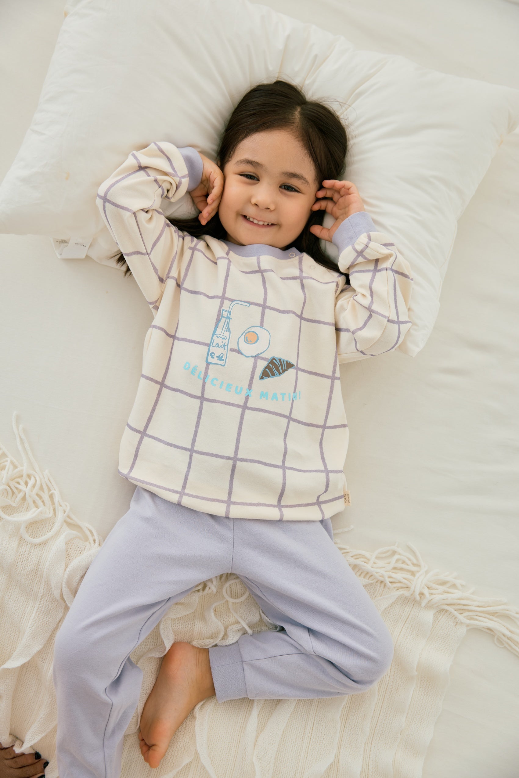 baby girl lying on the bed and wearing Organic Toddler Pajama Set-Milky