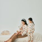 Mommy with 2 babies wearing norsu organic holiday special editon clothes and having fun on the bed