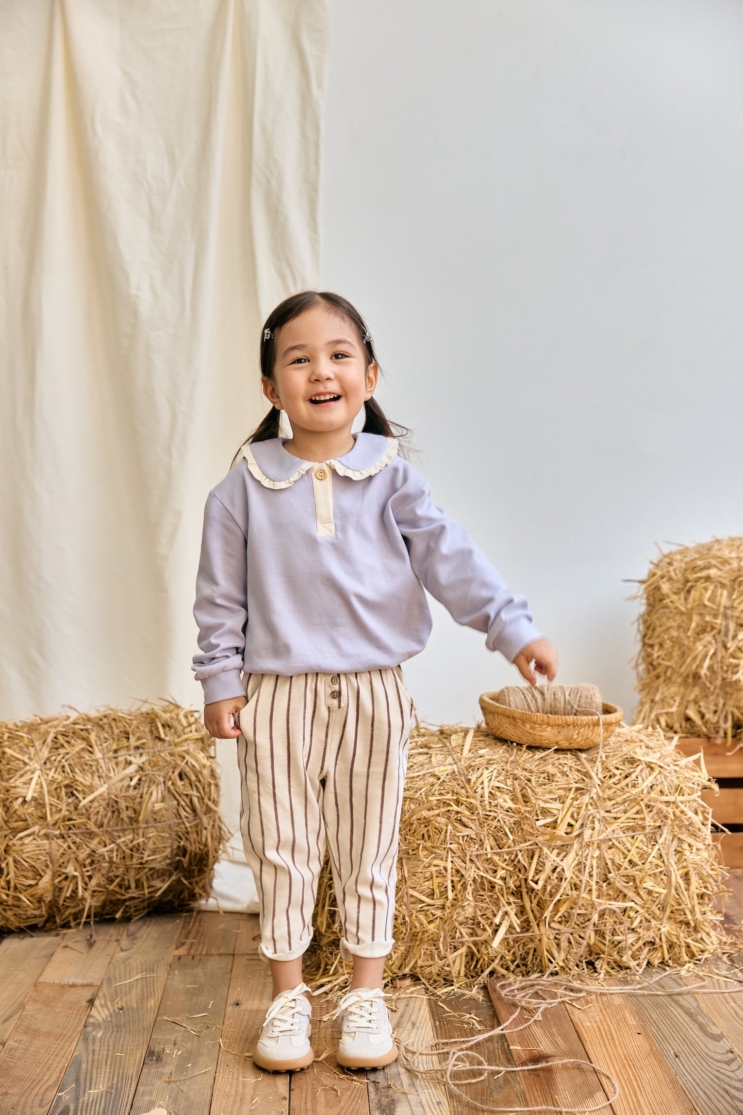 Toddler girl is standing on the floor and smiling