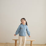 baby girl standing in front of a chair and wearing Toddler Organic Fleece Zip-up Sweatshirt-Symbols