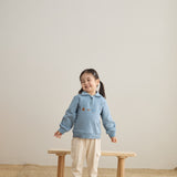 baby girl standing in front of a chair and wearing Toddler Organic Fleece Zip-up Sweatshirt-Symbols