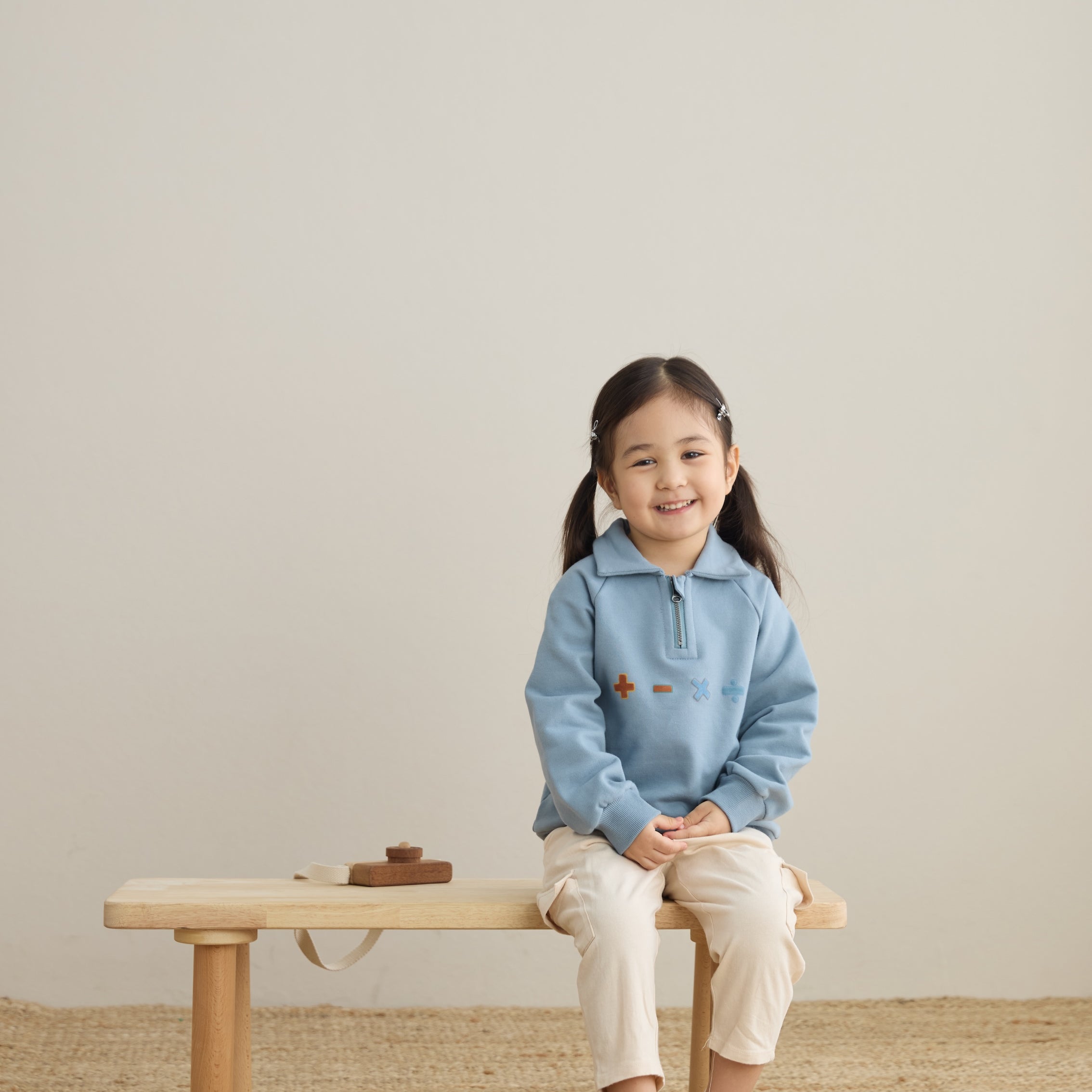 baby sitting on the chair and wearing Toddler Organic Fleece Zip-up Sweatshirt-Symbols