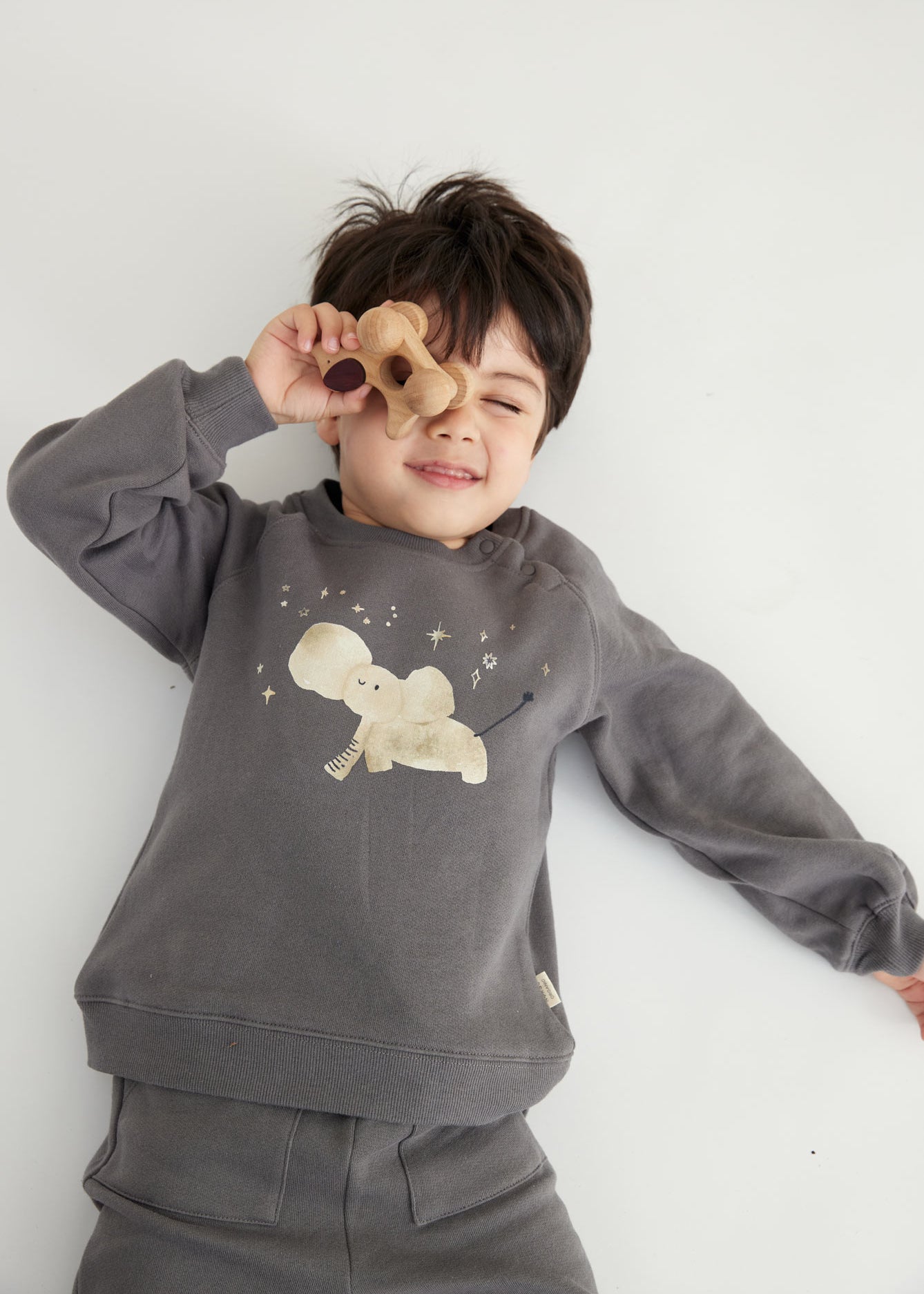 model lay down and wearing Toddler Organic Fleece Sweatshirt-Dark Grey