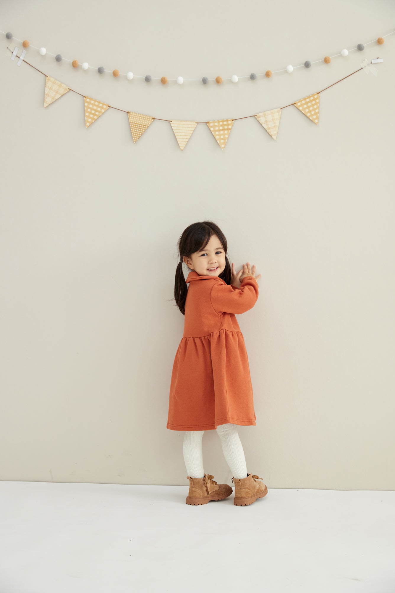 baby smiling and holding the wall