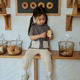 baby girl sitting on the table and hold a bread