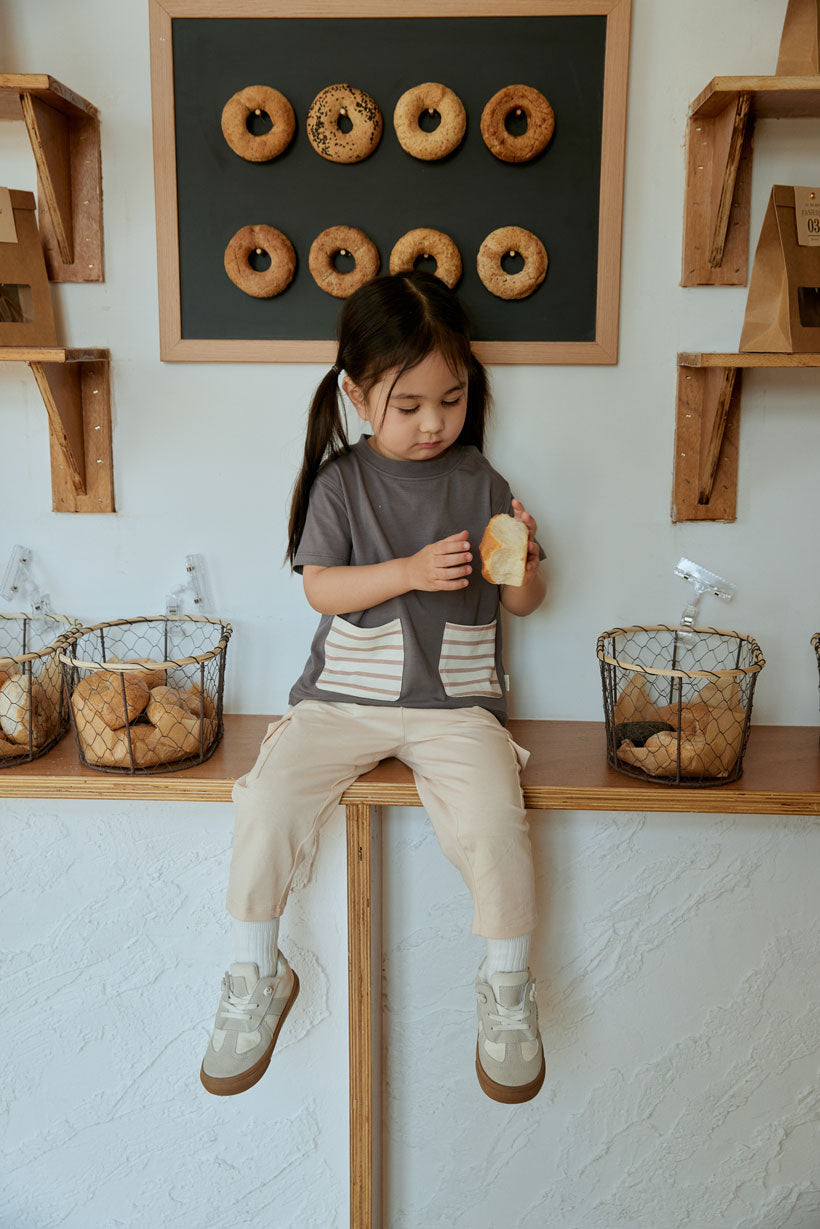 baby girl looking at here bread and sitting on the table