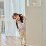 baby girl stand behind the door