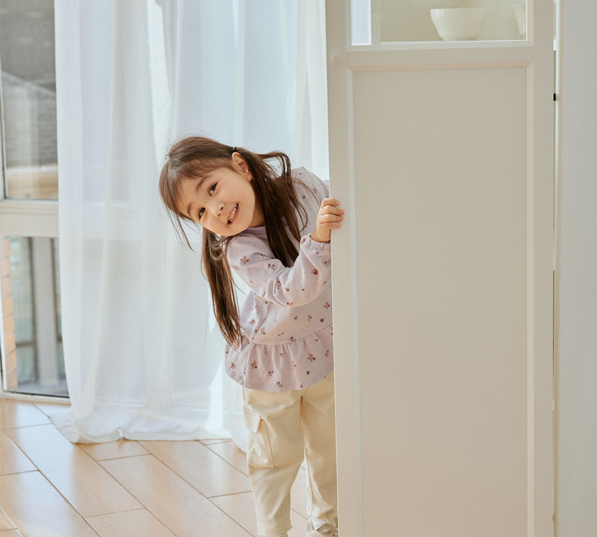 baby girl stand behind the door