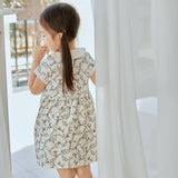 baby girl stand in front of the window and watching outside