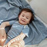 Boy lying on the bed smiling at you