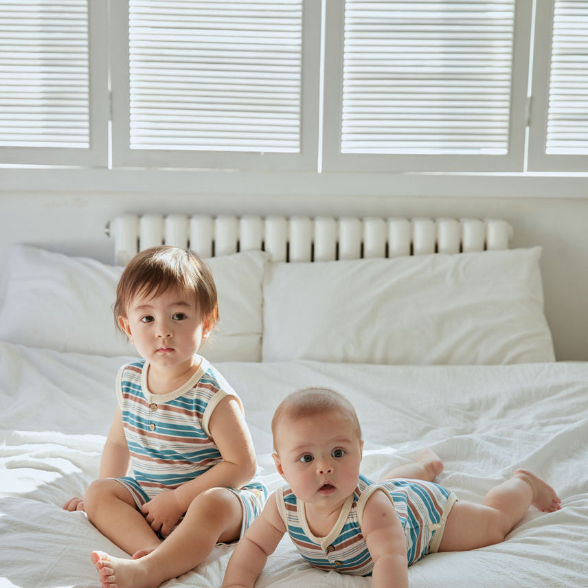 two baby boy sitting on the bed