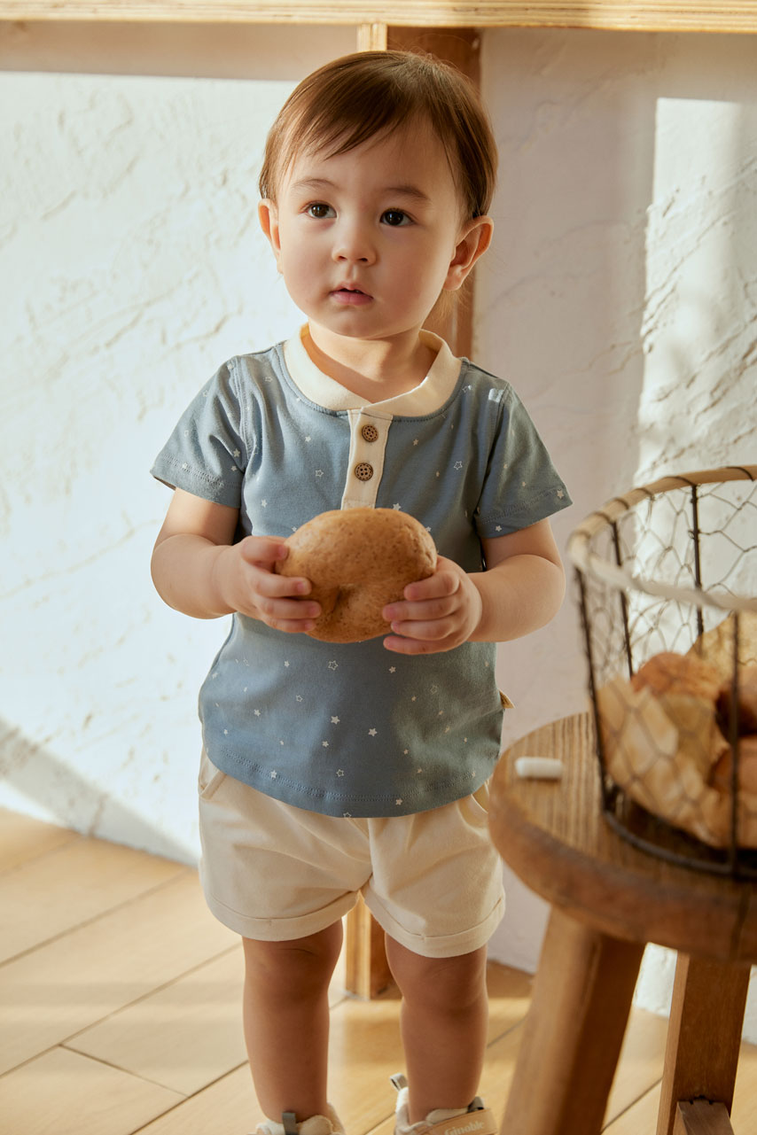 baby holding a bagel and look at you