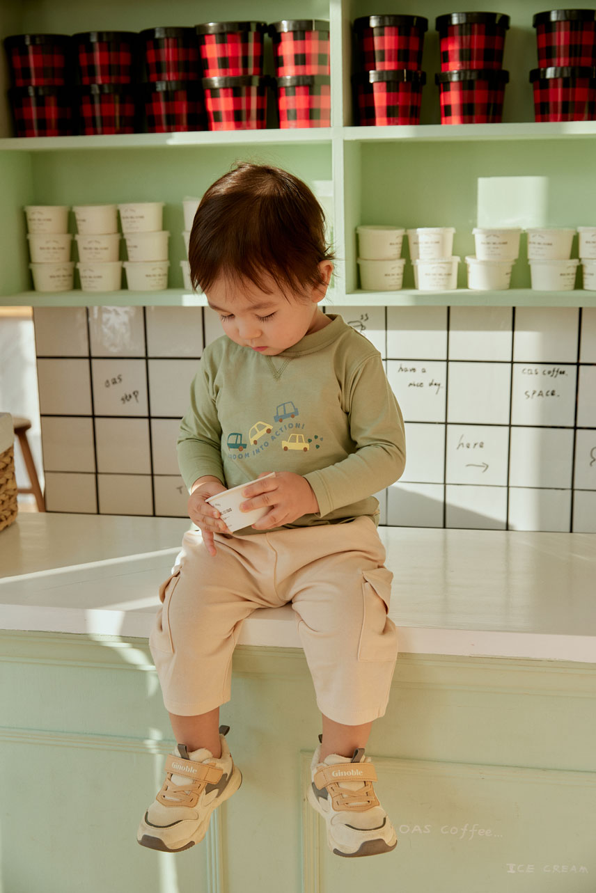 baby boy sitting on the table and holding a cup