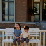 brother and sister are sitting on the bench