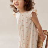 Child wearing a white dress with small patterns, holding a woven basket against a plain background