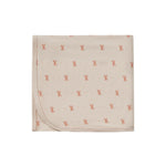Beige blanket with small red patterns on a white background