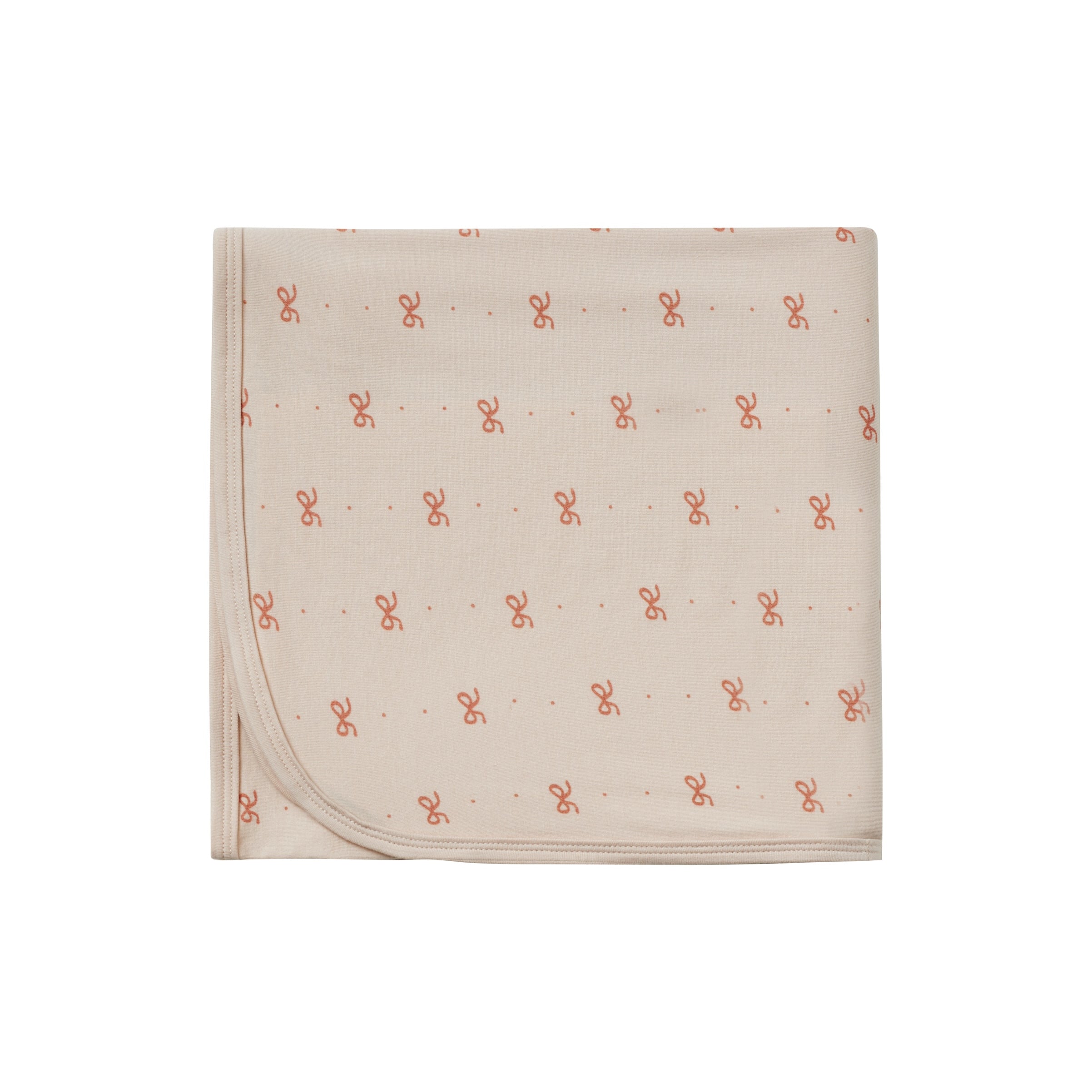 Beige blanket with small red patterns on a white background