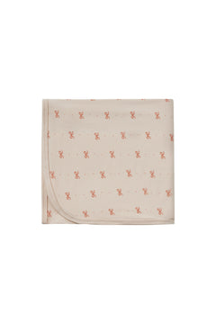 Beige blanket with small red patterns on a white background