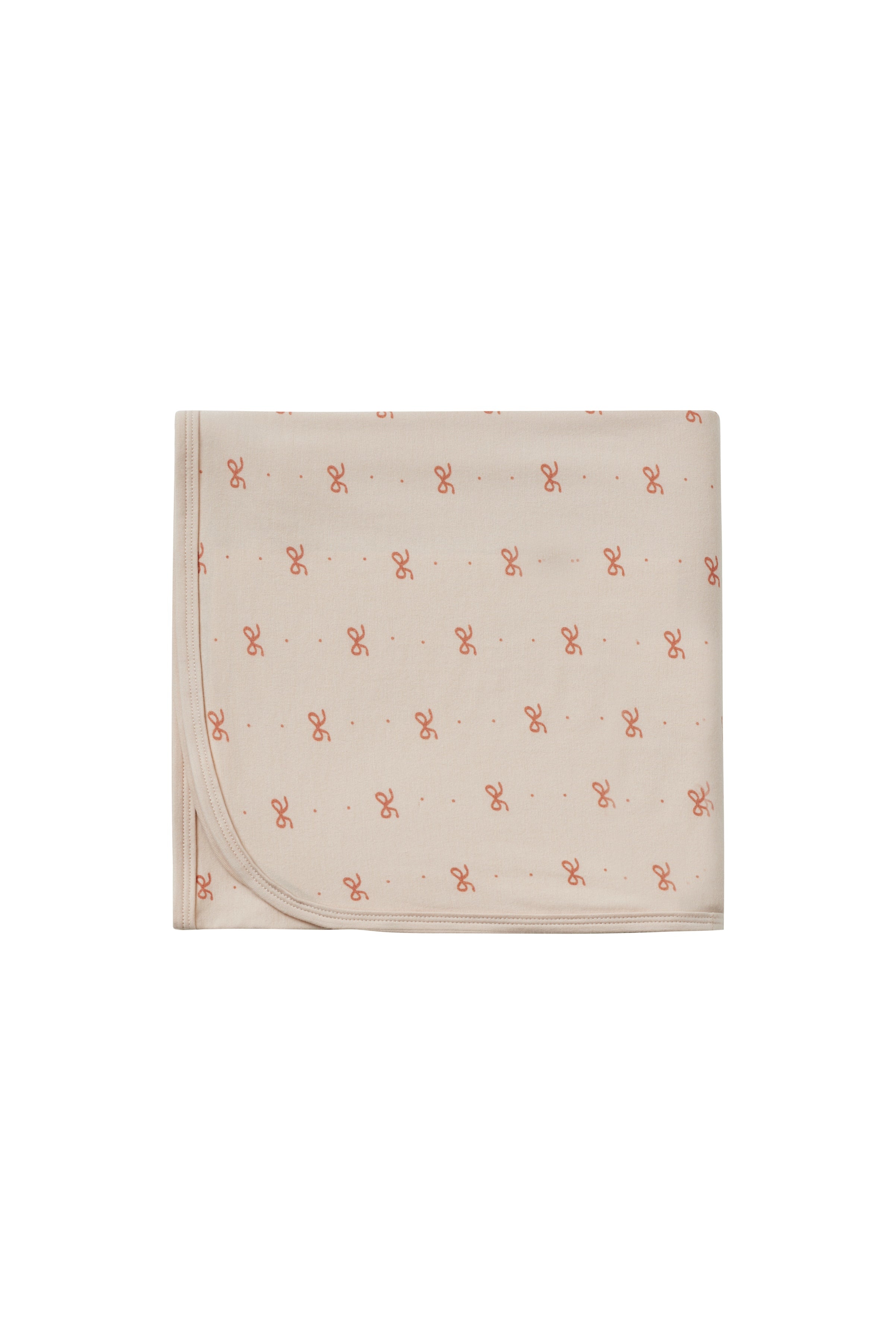 Beige blanket with small red patterns on a white background