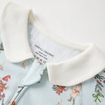 Close-up of a baby outfit with jolly pattern and white collar, featuring a visible brand label.