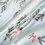 Close-up of a fabric with Christmas-themed designs including holly leaves, ribbons, and a snowman on a light blue background.
