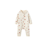 A long-sleeve baby romper in cream with a pattern of small red and pink hearts, featuring a front zipper and snap closure.