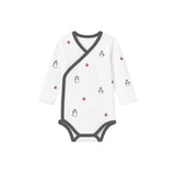 White baby onesie with penguin pattern on a white background
