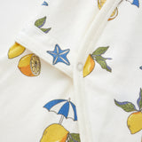 Close-up of a fabric with lemon and umbrella pattern on a white background