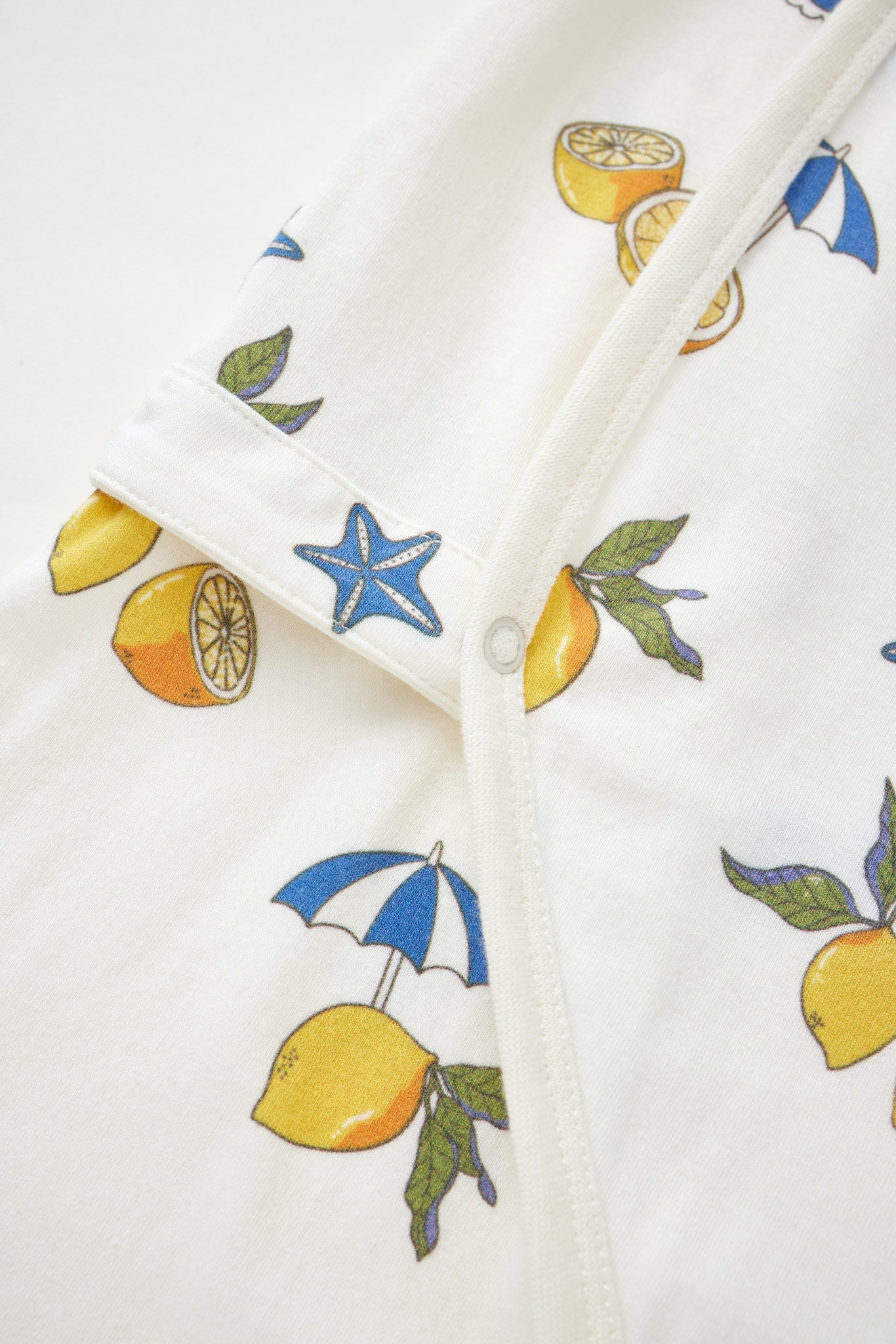 Close-up of a fabric with lemon and umbrella pattern on a white background