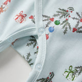 Close-up of a baby sleeper with Christmas-themed print on a light blue background