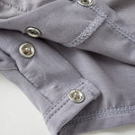 Close-up of a gray fabric with buttons on a white background