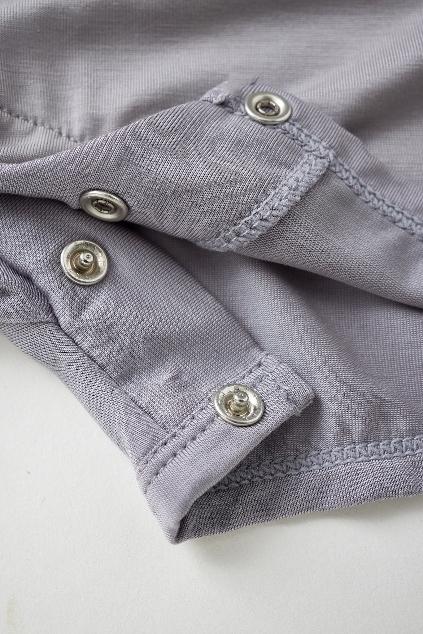 Close-up of a gray fabric with buttons on a white background