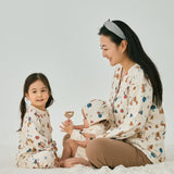 Mommy with 2 babies wearing norsu organic holiday special editon clothes and having fun on the bed