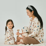 Mommy with 2 babies wearing norsu organic holiday special editon clothes and having fun on the bed