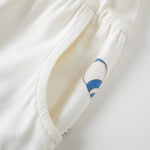 Close-up of a white garment with floral embroidery on a light background