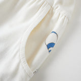 Close-up of a white garment with floral embroidery on a light background