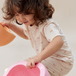 Child playing with a pink toy on a light background