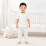 Child wearing a blue pajama set with star pattern in a minimalistic room.