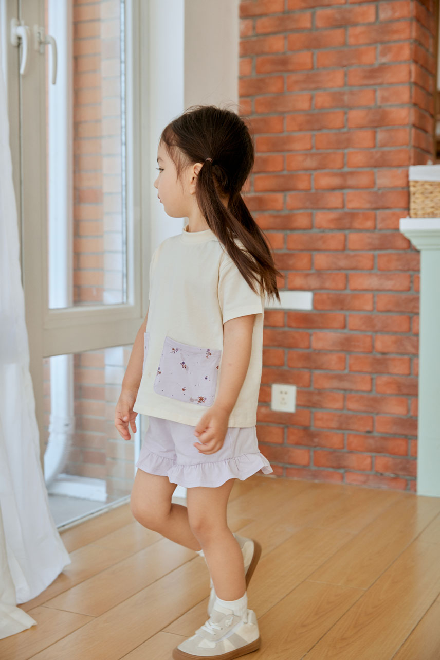 girl in white pocket shirt standing on the floor
