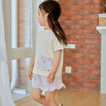 girl in white pocket shirt standing on the floor