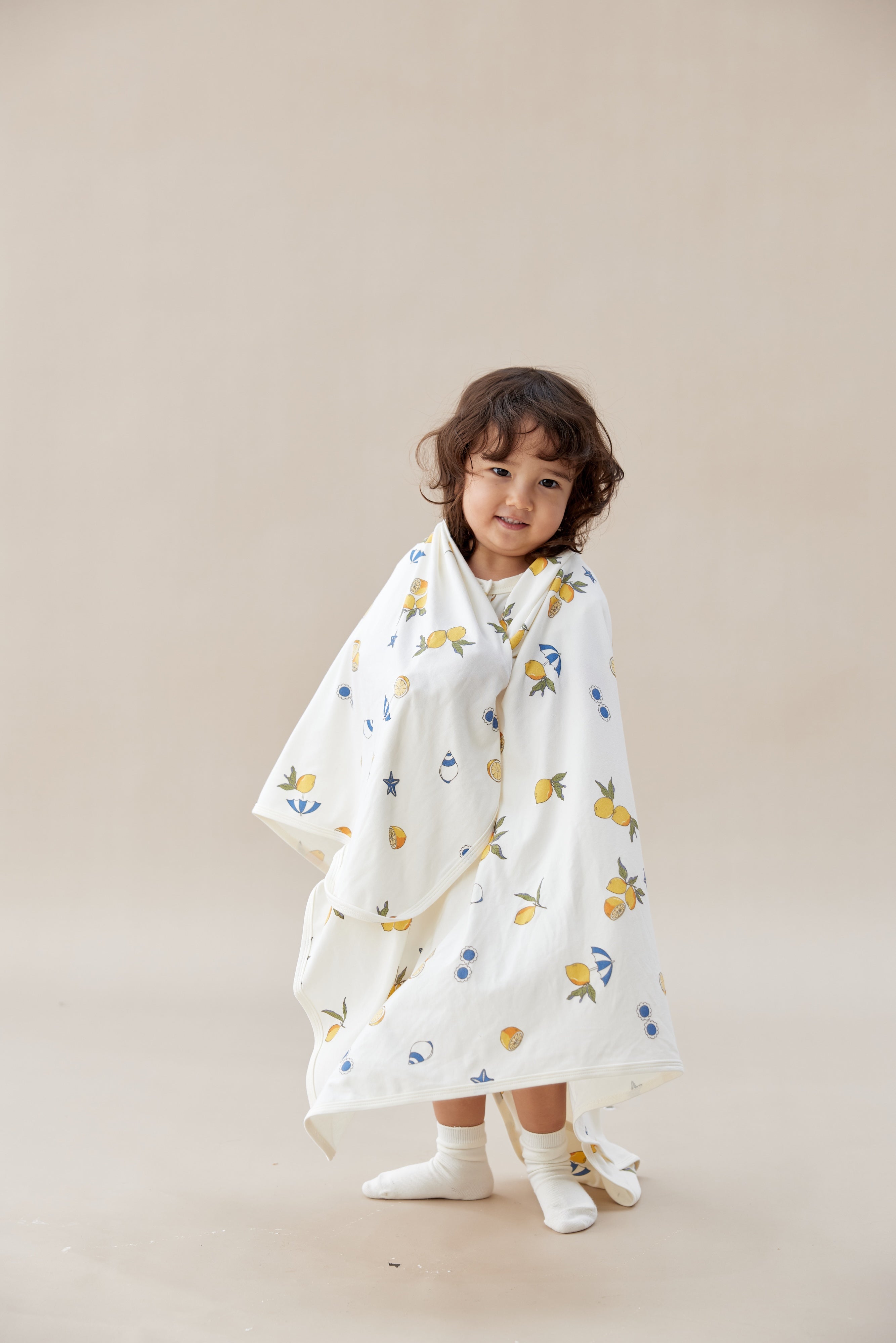 Child wearing a floral patterned baby wrap against a plain background